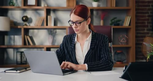 Business Woman Looking at Camera at Office Room Working on Laptop.