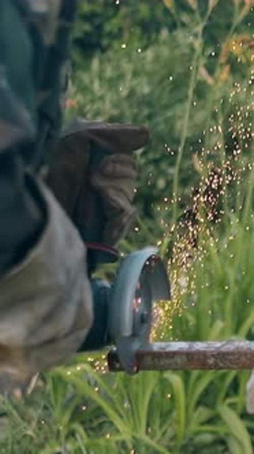 Slow Motion Backside View Man Cuts Metal Part with Disc Saw