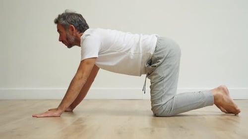 Man practicing inversion in green garden with relaxed focus