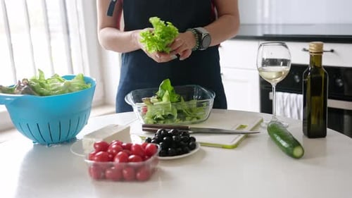Woman Tears Lettuce Leaves Into Bowl For Cooking