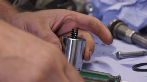 An Auto Mechanic Disassembles or Assembles a Part From a Car Engine