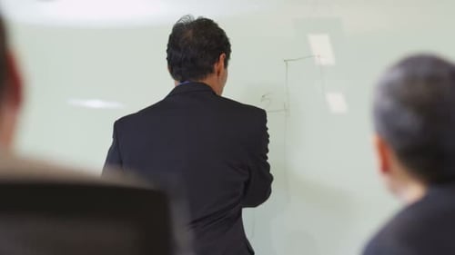 Businessman Drawing Graph on Whiteboard for Presentation