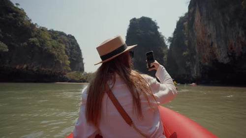 Mulher sentada no barco passando pela vista traseira da lagoa Mulher viajando na gôndola sentada na proa do navio