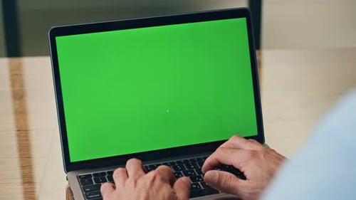 Typing on Laptop with Green Screen in Office