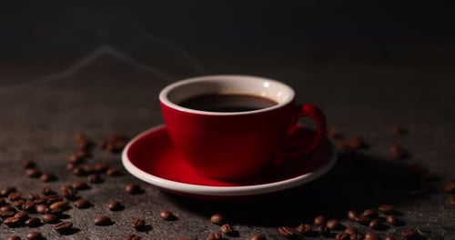 Steaming Coffee Cup Surrounded by Roasted Coffee Beans