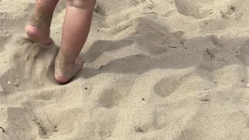 Child Walking Playfully on a Sandy Beach During Summer Days