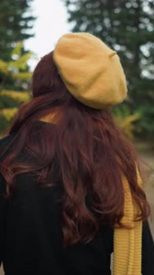 Artist Adjusts Hair While Walking in Autumn Park in Yellow Beret