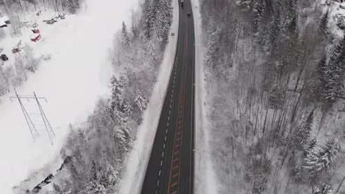 Winter Highway Through Snowy Forest - aerial drone shot