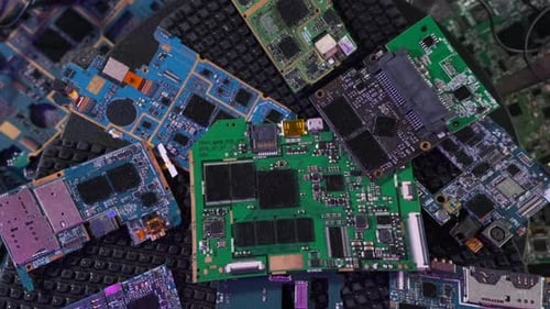 Stapel gebrauchter Mikrochips von Computern, Tablets, Telefonen drehen sich auf der Oberfläche, Nahaufnahme von oben.