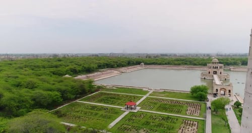 Survol aérien d'un monument en grès et d'une forêt à Hiran Minar au Pakistan