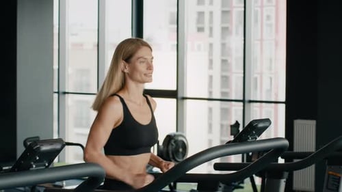 Fit Woman Jogging on Treadmill in Gym