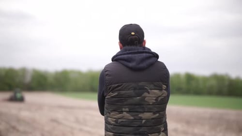 farmer watching his tractor planting sunflower at the field