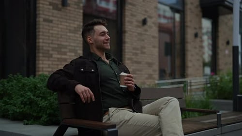 Man Relaxing with Coffee on Urban Bench