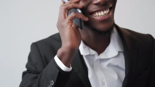 Smiling Man Talks on Smartphone in Office