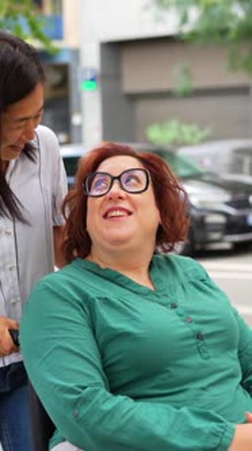 Woman with disability and friend strolling along the city