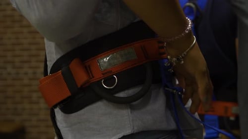 Gros plan : un client est attaché, harnais de sécurité, prêt à vivre une expérience en hélicoptère