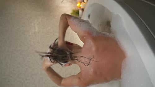 Woman Washing Hair in a Bubble Bath