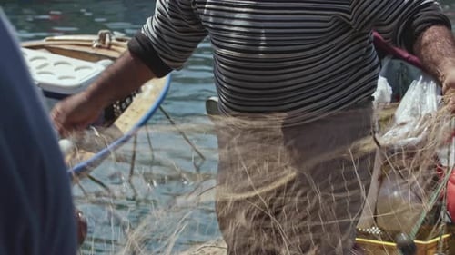 Der alte Fischer reinigt seine Netze vor dem Segeln