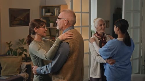 Senior Couple Dancing in Home with Younger Friends