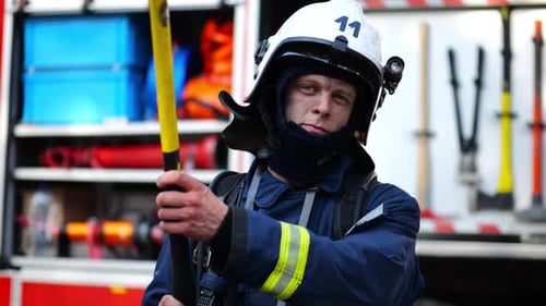 Portrait of Confident Male Fireguard with Axe Standing Near a Fire Engine Young Fireman with Dirty