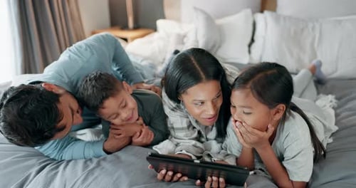 Happy Family Enjoys Tablet in Bed at Home