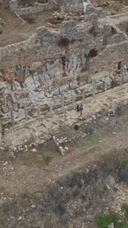 Vidéo verticale : promenade panoramique d'une famille dans une ville ancienne entourée de ruines et de charme historique