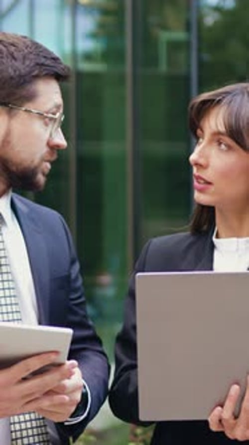 Businessman and Businesswoman Having a Serious Outdoor Meeting Discussing Important Work Topics
