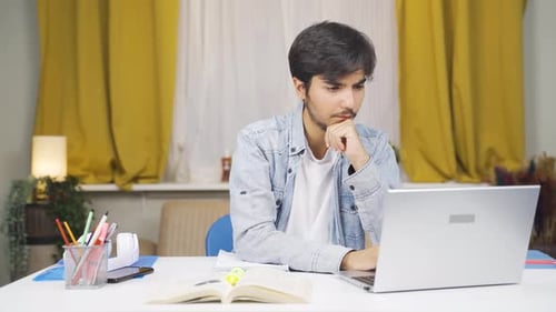 Young Adult Studying At Home with Laptop