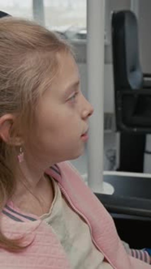 Child Looking into Phoropter During Eye Examination Vertical