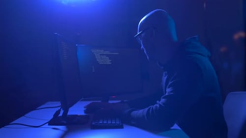 Man working at computer in blue lighted room