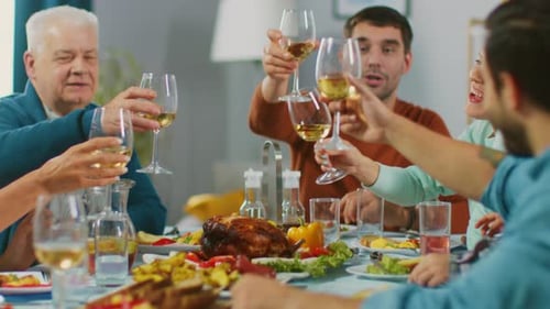Family and Friends Toasting with Wine at Dinner Table