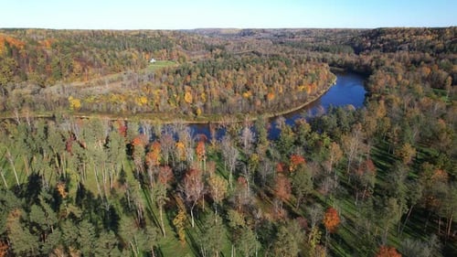 Colorful autumn landscape surrounding a winding river in a serene forest