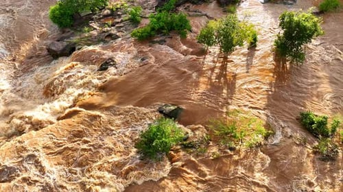 Vue aérienne : cascade inondée en mouvement.