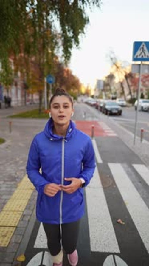 Front View of Beautiful Woman is Jogging Outdoor Autumn Day