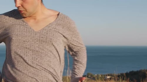 Young Man Stretching Arms by the Ocean