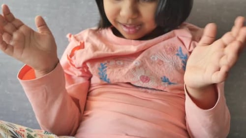 Smiling Child Clapping Hands in Home