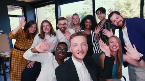 Diverse Team Smiling and Waving in Modern Office