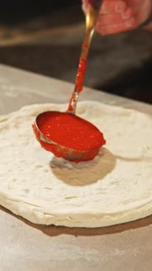 Applying Pizza Sauce to Dough with Ladle