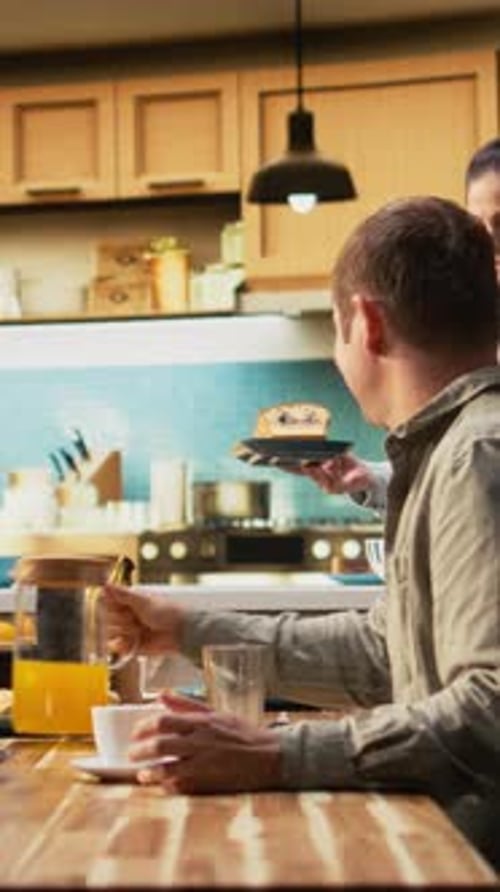 Vidéo verticale Famille avec une préadolescente servant le petit déjeuner ensemble dans une cuisine lumineuse