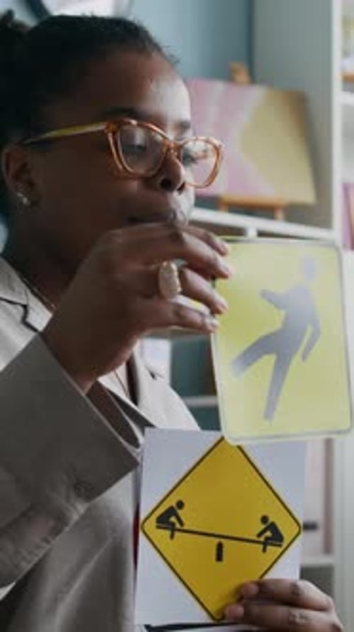 Vertical of Teacher Using Visual Aids to Teach Young Students Traffic Symbols