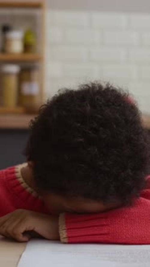 Schoolboy Falling Asleep while Doing Homework