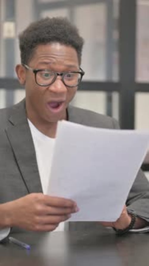 Excited Man Reads Good News in Office