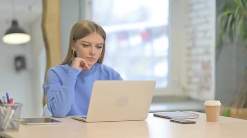 Young Woman Uses Laptop in Home Office