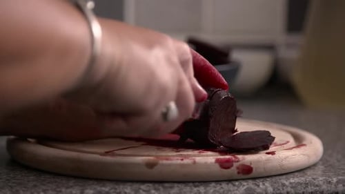 Woman's hands slicing homegrown Beetroot to prepare for home pickling.