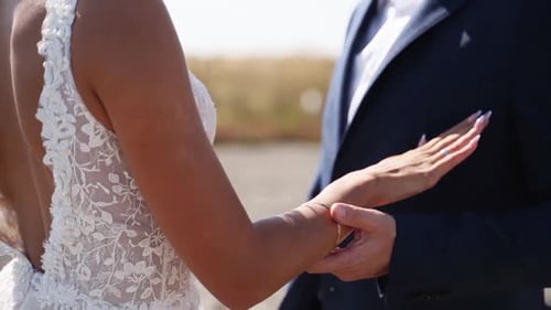 Newlyweds Holding Hands on the Beach