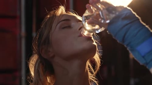 Sporty Girl Drinks Water After a Workout in the Gym