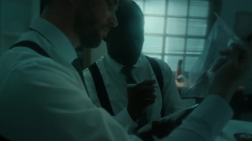 Two Detectives Examining Evidence in Crime Lab