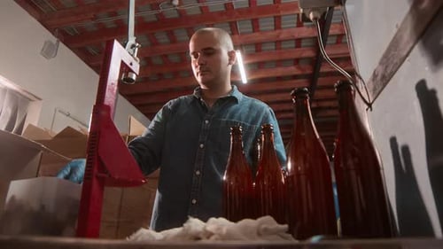 Man Working on Bottle Capping Machine at Cider Production Factory