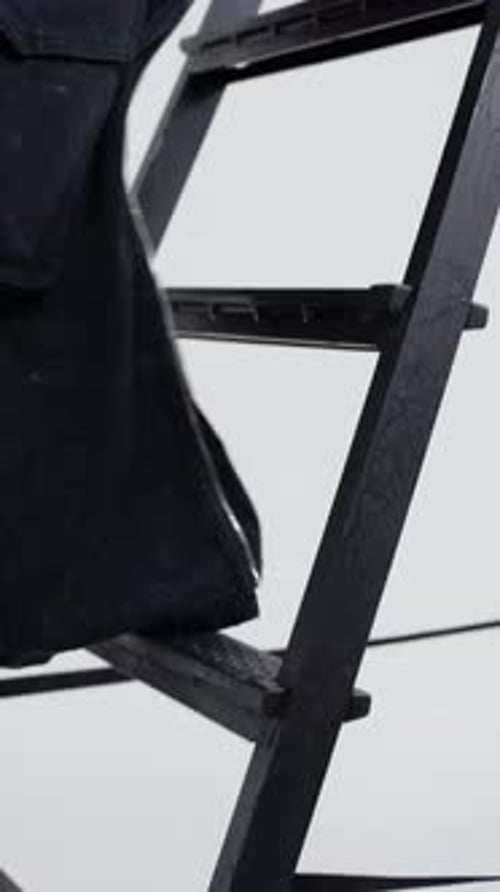 Close Up of Boots on Metal Ladder Steps