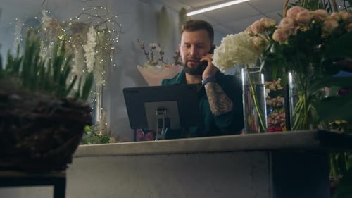Male Entrepreneur Florist Talks By Phone and Uses Tablet